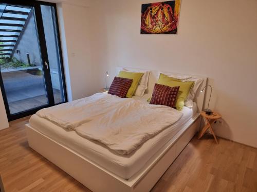 a white bed with pillows on it in a room at Quiet 1-bedroom in a basement of new villa in Prague