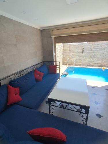 een woonkamer met een bank en een zwembad bij la sublime in Taghazout