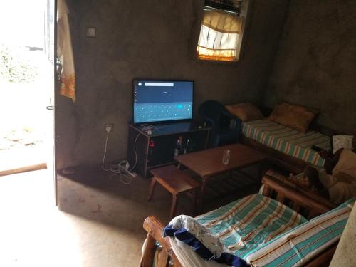 a living room with a computer and a desk with a laptop at Sunrise homestay Sipi in Kapchorwa