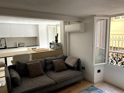ein Wohnzimmer mit einem Sofa und einer Küche in der Unterkunft Palais Gallia in Heart Monte Carlo 2 bed, 300m Casino Sq. in Beausoleil