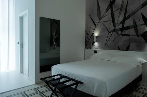 a bedroom with a white bed and a mirror at Domea Superior Rooms Bed and Breakfast in Reggio Calabria