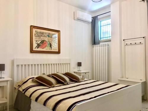 a white bedroom with a large bed with pillows at Da Raffaele in Fondi