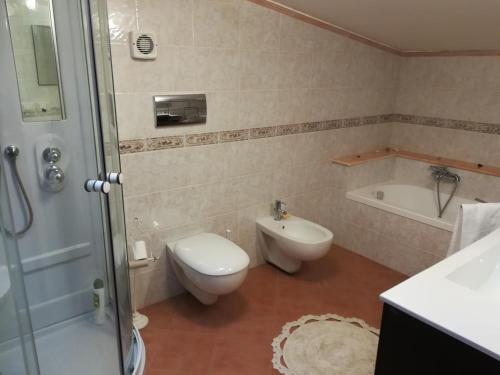 łazienka z toaletą, umywalką i wanną w obiekcie Casa Carmelo w mieście Nizza di Sicilia