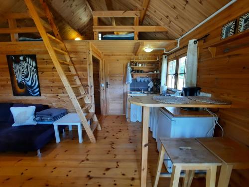 ein Zimmer mit einem Tisch und Treppen in einem winzigen Haus in der Unterkunft Zielony domek na Kaszubach in Dziemiany