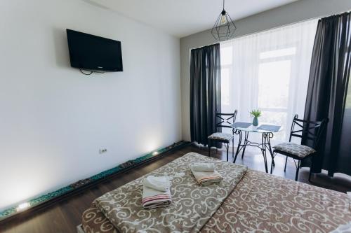 a bedroom with a bed and a table with chairs at Apartments біля ЖД вокзалу in Ivano-Frankivsʼk