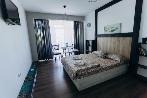 a bedroom with a bed and a table with chairs at Apartments біля ЖД вокзалу in Ivano-Frankivsʼk