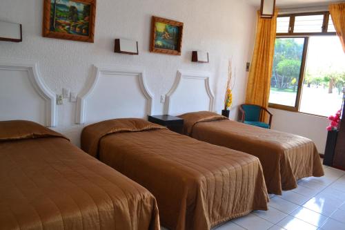 a hotel room with two beds and a window at Hotel Paraiso in Tepic
