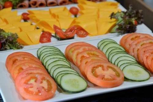 a plate of food with tomatoes cucumbers and cheese at Road Lodge Rivonia in Johannesburg