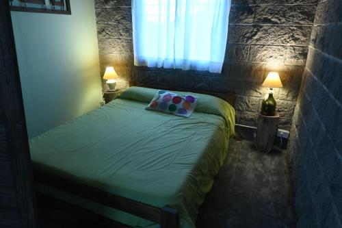 - une chambre avec un lit vert et une fenêtre dans l'établissement Aldea Cumelén, à Campos Salles