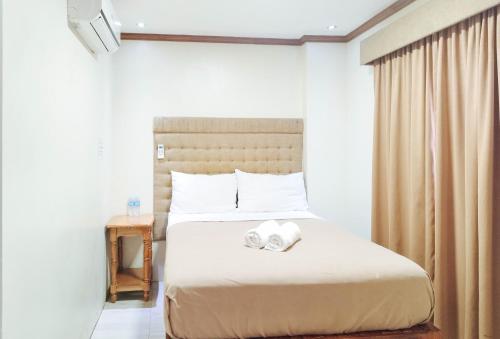 a bedroom with a bed with two towels on it at RedDoorz @ near Caticlan Port in Aklan