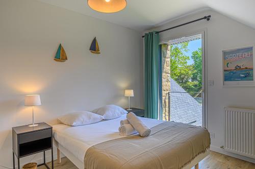 a bedroom with a bed and a large window at Les Dryades - Villa familiale proche plage in Sarzeau