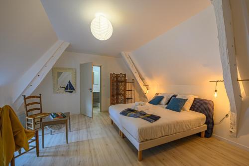 1 dormitorio con 1 cama, 1 mesa y 1 silla en Le Stevan - Maisonnette en duplex campagne vannetaise, en Grand-Champ