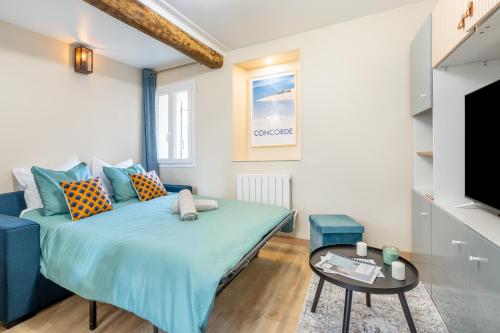 een kleine slaapkamer met een blauw bed en een tafel bij La Perle de Laigneville - Proche Parc Astérix & Chantilly, parking public gratuit, Wifi & Netflix 