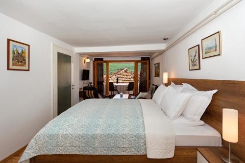 a hotel room with a bed and a balcony at INES APARTMENTS in Ohrid