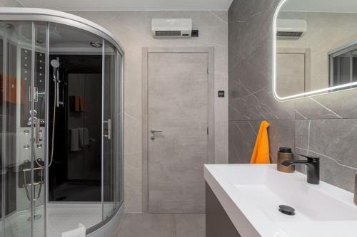 y baño con lavabo y ducha con espejo. en Villa Romano by IstriaLux, en Benažići