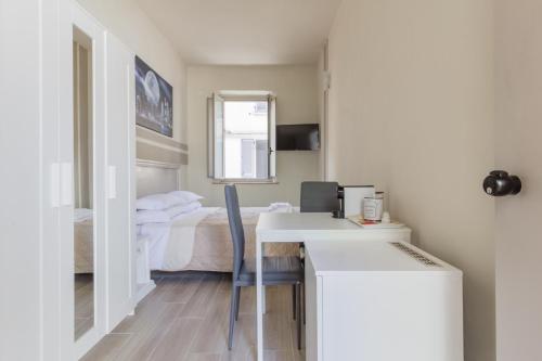 a room with a bed and a desk and a room with a bedroom at Center Rooms in Piacenza