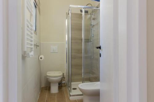 a bathroom with a toilet and a glass shower at Center Rooms in Piacenza