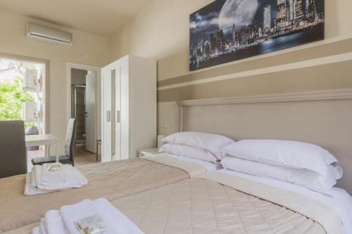 a bedroom with a large bed with white pillows at Center Rooms in Piacenza