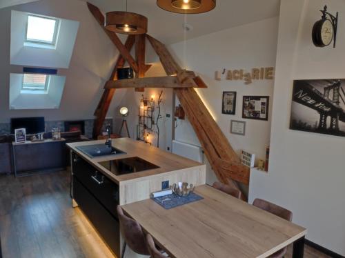 a kitchen with a sink and a wooden table at Logis 39 in Champagnole