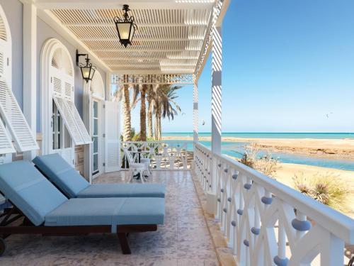 a porch with a blue couch and the beach at La Maison Bleue El Gouna in Hurghada