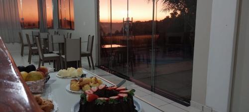 a table with two cakes on a table with a view at Pousada Colina do Sol in Ametista do Sul