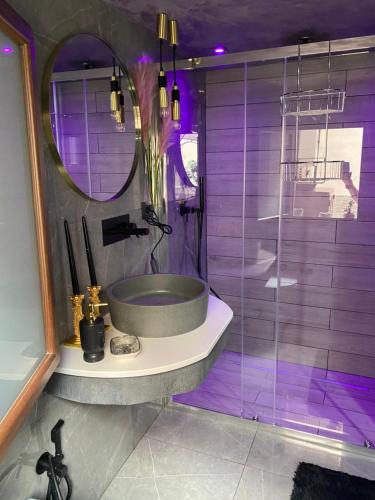 a purple bathroom with a sink and a mirror at Il cortiletto28 Rooms & House in Siracusa
