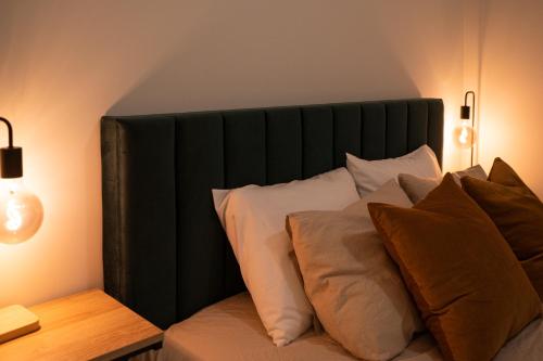 a bed with a black headboard with pillows on it at Apartment in Kesterciems in Ķesterciems