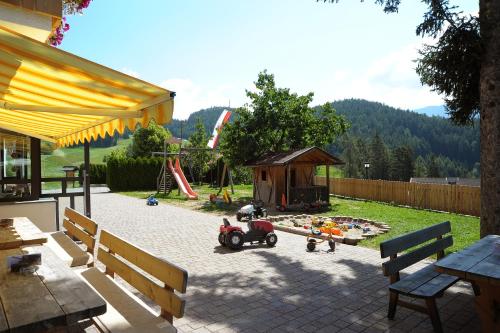 a playground with a toy motorcycle and a play structure at Jausenstation Moar in Funes