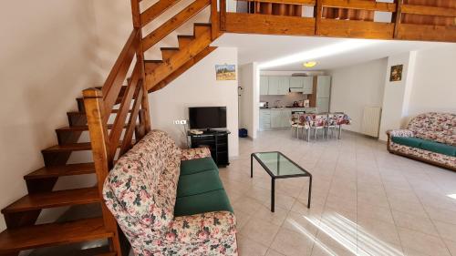 een woonkamer met een trap, een bank en een tafel bij Bonaventura Appartamenti 12345 Agriturismo Gardola Centro Storico in Tignale