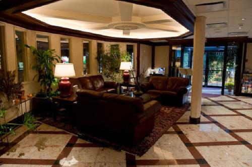 a living room with a couch and a table and chairs at Norwalk Inn & Conference Center in Norwalk