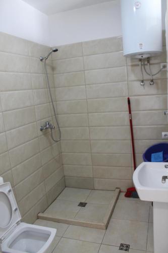 a bathroom with a shower with a toilet and a sink at Blue Apartments & Hotel Shengjin in Shëngjin