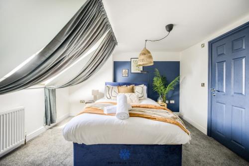 a bedroom with a large bed and a blue door at Doncaster Large Luxury 3 Bedroom House, Sleeps 8, City Centre, Racecourse, Free Parking, by EMPOWER HOMES in Doncaster