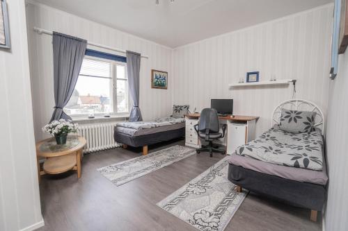1 dormitorio con cama, escritorio y escritorio en Iso ja viihtyisä asunto Pietarsaaressa, en Jakobstad