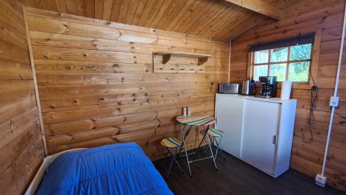 eine Küche mit einem Kühlschrank und einem Tisch in einer Hütte in der Unterkunft Knuffiges Ferienhaus Sternchen in Zinnowitz