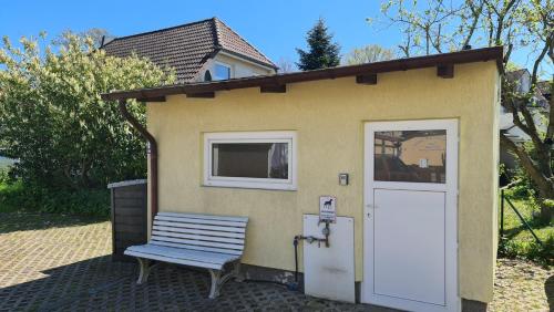 齊諾維茨的住宿－Ferienholzhaus Sternchen mit Terrasse，一个小棚子,有长凳和门