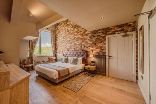 a bedroom with a brick wall and a bed and a door at Sandburn Hall in York
