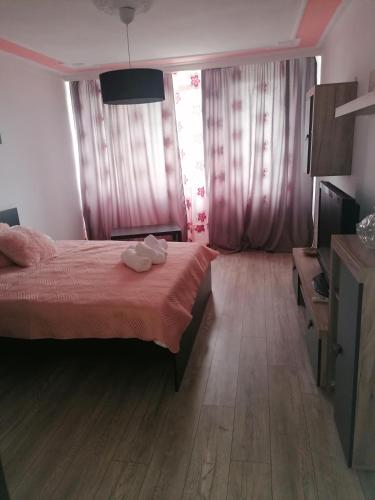 a bedroom with a bed with a red bedspread at Garsoniera P2 in Craiova
