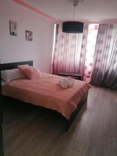 a bedroom with a bed with a red comforter at Garsoniera P2 in Craiova