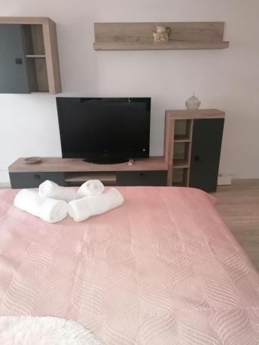 a bedroom with two towels on a bed with a tv at Garsoniera P2 in Craiova