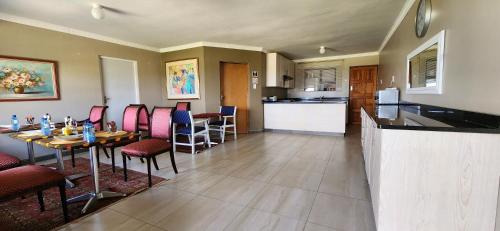 a kitchen and dining room with a table and chairs at Vikamana Guest House in Ulundi