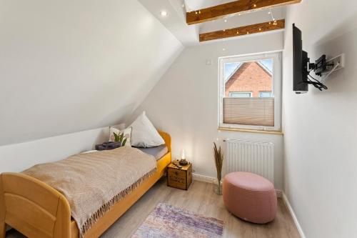 a small bedroom with a bed and a window at Huus Frieda in Krummhörn