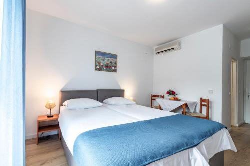 una camera da letto con un grande letto con una coperta blu di Villa Doris a Zaton