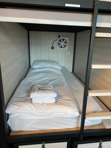 a bunk bed with two towels on the bottom bunk at Capsule Hostel by StayStay in Nuremberg