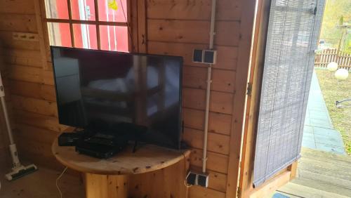 einen TV auf einem Holztisch vor einem Fenster in der Unterkunft rustikales Holzhaus Strandbude in Ahlbeck