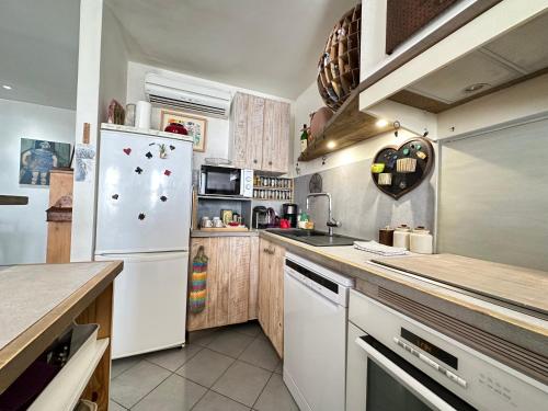 une cuisine avec un réfrigérateur blanc et un comptoir dans l'établissement Bel appartement au coeur de Sanary, à Sanary-sur-Mer