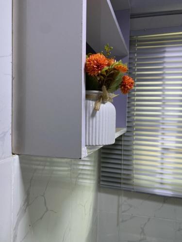 a vase with flowers on a shelf in a bathroom at HOUSE 27 HABITAT in Lagos
