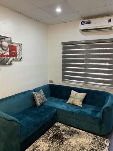 a living room with a blue couch in a room at HOUSE 27 HABITAT in Lagos