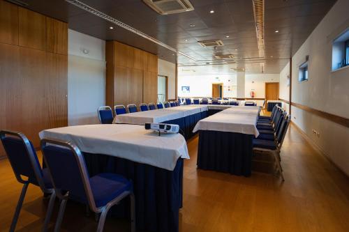 a row of tables and chairs in a room at Hotel Pombalense in Pombal