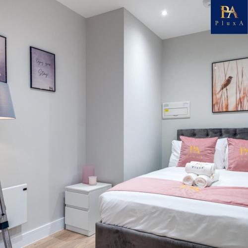 a bedroom with a bed with pink and white at Pluxa Blush - Blush Gem with Private Entrance, Workplace, Harrow Haven in Harrow