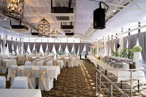 a banquet hall with white tables and white chairs at RM Hotel in Muar